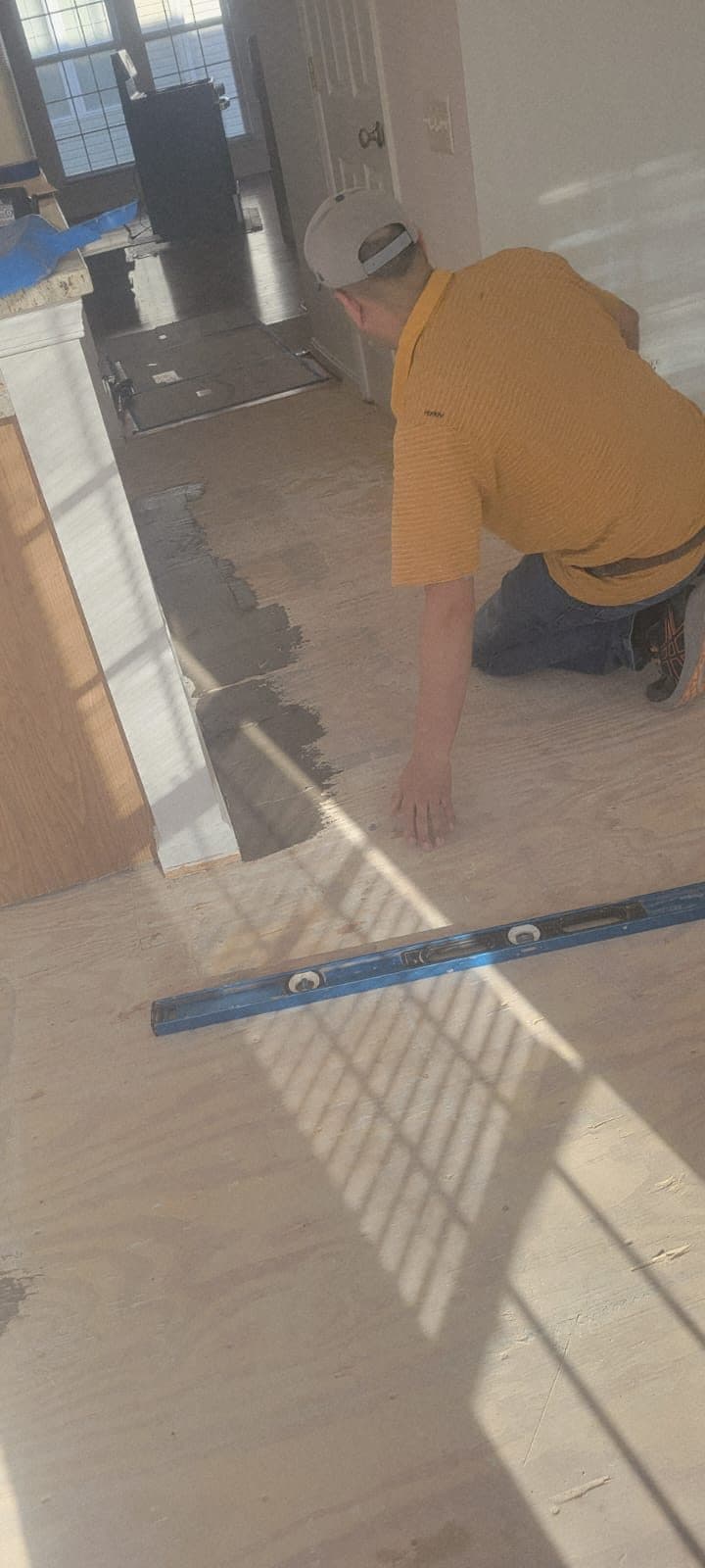 Subfloor leveling in progress near a kitchen entryway