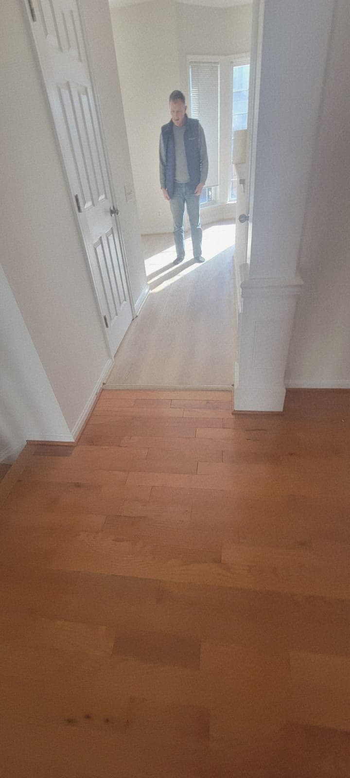 Hallway showing the transition between new flooring and the home's existing hardwood